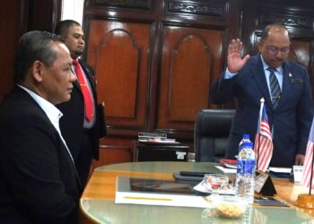 AMINUDDIN Harun (kiri) menyaksikan angkat sumpah Mohd. Zafir sebagai Setiausaha Kerajaan Negeri Sembilan di Pejabat Menteri Besar Negeri Sembilan di Wisma Negeri, Seremban hari ini.-UTUSAN/BADRUL HAFIZAN MAT ISA.