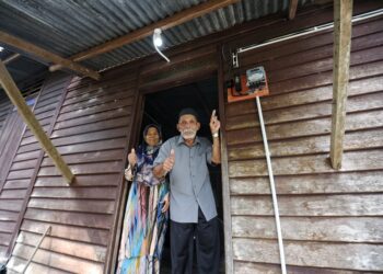 SHARIF Sumun bersama isterinya, Saonah Mat, 67, gembira selepas rumah yang mereka diami sejak lebih 50 tahun lalu telah menerima bekalan elektrik lebih sempurna menerusi projek BELB Kementerian Kemajuan Desa dan Wilayah yang dilaksanakan di Kampung Dusun Umbut dan Kampung Chalin, Chennah, Jelebu.-UTUSAN/MOHD. SHAHJEHAN MAAMIN.