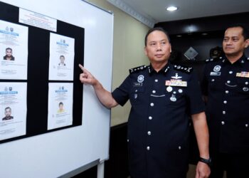 AHMAD Dzaffir Mohd. Yussof menunjukkan gambar empat lelaki yang sedang diburu polis bagi membantu siasatan kes penipuan pelaburan tidak wujud di Facebook dalam sidang akhbar di IPK Negeri Sembilan di Seremban hari ini.-UTUSAN/MOHD. SHAHJEHAN MAAMIN.