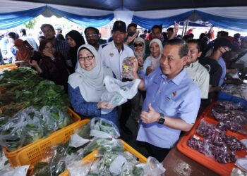 AMINUDDIN Harun dan Fuziah Salleh menunjukkan barangan yang dijual pada program Jualan Harga Ladang Nismilan Prihatin yang diadakan sempena Majlis Pelancaran Jualan Rahmah Peringkat Negeri Sembilan di Sikamat, Seremban hari ini.-UTUSAN/MOHD. SHAHJEHAN MAAMIN.