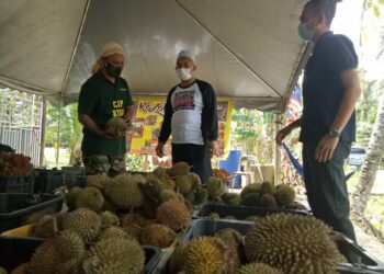 RAZMAN Zakaria (tengah) bertemu dengan pemborong durian yang mendakwa berlaku lambakan durian, Mohd. Firdaus Endut di Ijok dekat Larut, Perak,  hari ini.  - UTUSAN/WAT KAMAL ABAS