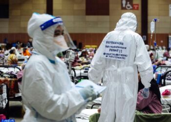 Seorang doktor kontrak menggantung plakad pada pakaian PPE yang dipakainya sebagai tanda menyokong perhimpunan aman Gerakan Hartal Doktor Kontrak di Maeps Serdang Julai lalu. – UTUSAN/FAISOL MUSTAFA