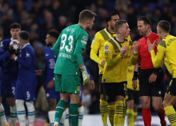 PEMAIN Borussia Dortmund mengerumuni pengadil, Danny Makkelie (dua, kanan) selepas dia mengarahkan sepakan penalti Chelsea diambil semula dalam  aksi Liga Juara-Juara di London semalam. – AFP
