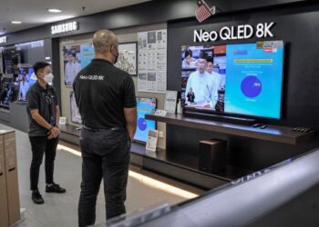 PEKERJA kedai elektronik mendengar Anwar Ibrahim membentangkan Belanjawan 2023 Malaysia Madani, semalam. - UTUSAN/FAIZ ALIF AHMAD ZUBIR