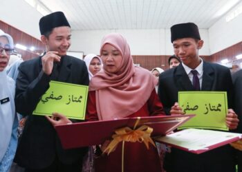 Fadhlina Sidek melihat keputusan Muhammad Zaurein Rosman (kiri) dan Muhammad Shahrul Nizam Mustapha di SMAT Tengku Ampuan Rahimah, Kuala Langat, Selangor, semalam. – UTUSAN/AFIQ RAZALI