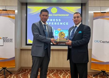 WAN Nazri Wan Aria (kiri) memberi saguhati kepada David Nour selepas sidang akhbar mengenai kerjasama kedua-dua syrikat di Kuala Lumpur, hari ini.