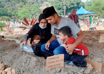 MOHD. Bukhari Zainal Annuar dan isteri, Siti Khadijah Daud bersama salah seorang anak mereka selepas majlis pengkebumian Muhammad Fawwaz Adli di Tanah Perkuburan Islam, Senawang, Seremban, pagi tadi.-UTUSAN/BADRUL HAFIZAN MAT ISA.