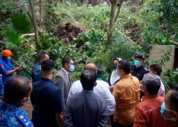 AHMAD Faizal Azumu (tengah) diberi penerangan semasa meninjau lokasi kejadian tanah runtuh di sebuah pusat peranginan di Tambun, Ipoh, Perak.