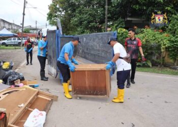 SUKARELAWAN daripada Southern Volunteers membantu membersihkan barangan penduduk di sekitar Batu Pahat yang rosak ditenggelami banjir.