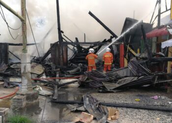 BOMBA memadamkan kebakaran di empat rumah kedai dua tingkat di Jalan Sulaimani di Chukai, Kemaman, Terengganu, hari ini. - NIK NUR IZZATUL HAZWANI NIK ADNAN