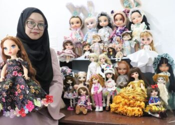 Siti Norhayati Salleh bersama sebahagian daripada koleksi baju anak patung yang dijenamakan sebagai Olumis Dolls. Harga ditawarkan bermula RM10 hingga RM100.