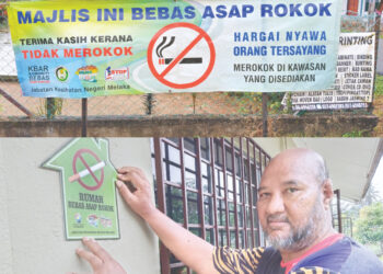 JAAFAR Atan menampal pelekat Rumah Bebas Asap Rokok di rumah seorang penduduk Kampung Sungai Jernih di Lubok Cina, Melaka yang mengambil bahagian dalam program MyHouse.