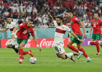 Pemain pertahanan Maghribi, Jawad El Yamiq (dua dari kiri) mematahkan serangan pemain tengah Portugal, Bruno Fernandes dalam saingan suku akhir. Maghribi menang 1-0. - AFP