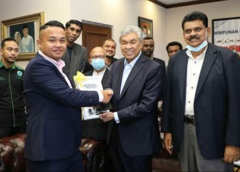 WAKIL GAPP Bas Malaysia, Mohamed Nazim Mohamed Nasay (kiri) menyerahkan surat kepada Ahmad Zahid Hamidi bagi memohon bantuan menyelesaikan masalah pengusaha bas yang terkesan akibat Covid-19 di Ibu Pejabat UMNO, Kuala Lumpur, semalam.