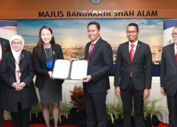 MOHD. Rashidi Ruslan (tiga dari kanan) dan Jacqueline Chang (tiga dari kiri) menunjukkan dokumen komitmen kerjasama kedua pihak bagi mengatasi masalah perubahan iklim secara global di Wisma MBSA, Shah Alam, Selangor, hari ini. - FOTO/ABDUL RAZAK IDRIS