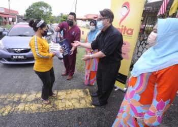 HENDERIC Koo Teck Leng (dua dari kanan) bersama Fadilah (tiga dari kanan) dan Dr. Maidin (dua dari kiri) menyampaikan sumbangan kepada seorang penerima pada Program Penyerahan Bakul Makanan Hospital Pakar CMH di Taman Marida, Senawang, Seremban hari ini. - UTUSAN/MOHD. SHAHJEHAN MAAMIN