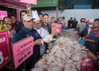 MOHAMAD Sabu (dua kiri) melancarkan jualan murah ayam proses segar ketika melakukan lawatan kerja ke Syarikat Ayam Bismi di Simpang Empat Kangkong, Alor Setar. - UTUSAN/ SHAHIR NOORDIN