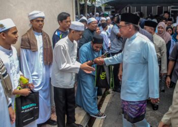 ANWAR Ibrahim beramah mesra dengan orang ramai dan pelajar-pelajar ketika hadir ke Majlis Sambutan Jubli Intan Sekolah Menengah Agama Nahdhah Hasanah di Kampung Melele, Kodiang. - UTUSAN/SHAHIR NOORDIN