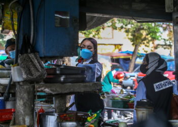 PEGAWAI kesihatan memeriksa tahap kebersihan dan kualiti makanan yang dijual oleh peniaga dalam operasi bersepadu di Simpang Kuala, Alor Setar- UTUSAN/ SHAHIR NOORDIN