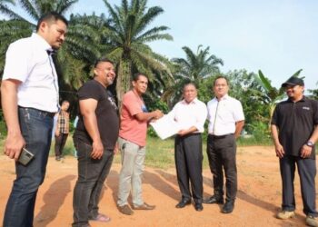 MOHD. Nizar Zakaria (tiga dari kanan) menyerahkan inden kepada wakil kontraktor baharu yang dilantik bagi membina sebuah unit RMR di Kampung Tarun, Lenggeng, Seremban, petang tadi.-UTUSAN/BADRUL HAFIZAN MAT ISA.