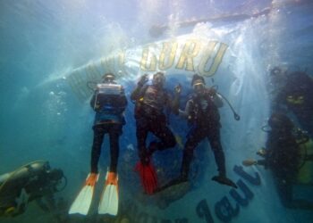 TIGA guru merakam gambar kenangan meraikan Hari Guru di dasar Laut di Pulau Perhentian Besut, Terengganu, semalam.  