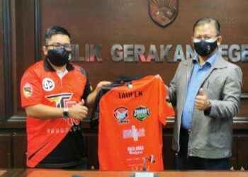 PRESIDEN NSEA, Muhammad Faries Faizal Shamsul (kiri) menyerahkan jersi kepada Mohamad Taufek selepas Majlis Menandatangi Perjanjian Persefahaman di antara Tabah dan NSEA di Seremban hari ini. - UTUSAN/AFIFI HAFIZ MOHD. NOR