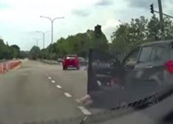 TANGKAP LAYAR kejadian memaparkan  seorang wanita keluar ketika kenderaan Perodua MyVi yang dinaikinya masih bergerak berhampiran persimpangan lampu isyarat di Seksyen 7, Shah Alam, Selangor.