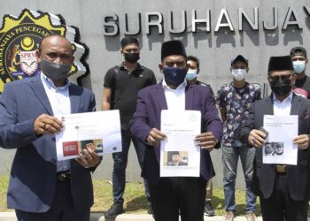 SYED Muhammad Imran SN Syed Abdul Aziz (tengah) menunjukkan laporan yang dibuat ke atas Tengku Datuk Seri Zafrul Tengku Abdul Aziz dan Mohd. Nazlan Mohd. Ghazali di pekarangan Ibu Pejabat SPRM, Putrajaya. - UTUSAN/FAISOL MUSTAFA