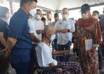 HALIMAH Mohamed Sadique (kanan) menyantuni seorang warga emas berusia 81 tahun ketika melawat lokasi kebakaran di Kampung Baru Karak di Bentong, Pahang. - FOTO/SALEHUDIN MAT RASAD