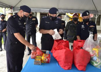 MIOR Faridalathrash Wahid (tengah) melihat kotak makanan untuk anggota pasukan keselamatan yang  bertugas di kawasan PKPD Daerah Batang Padang di Tapah hari ini. - UTUSAN/ZULFACHRI ZULKIFLI