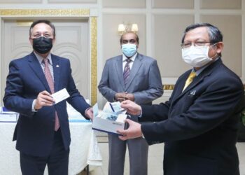 HASNI Mohammad (kiri) menyerahkan kit ujian Covid-19 kepada Dr. Aman Rabu sambil diperhatikan R. Vidyananthan (tengah) di Pejabat Menteri Besar Johor, Kota Iskandar, Iskandar Puteri, Johor.