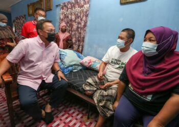 HASNI Mohammad (kiri) bertanya khabar Zainal Mohamad Darwish semasa menyampaikan wang tunai sebanyak RM500 yang diberikan menerusi PRE Ihsan Johor 3.0 di Kampung Bakar Batu, Johor Bahru hari ini.