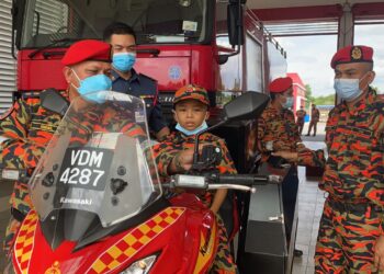 MUHAMMAD Haziq Mohd. Asyraf gembira apabila berpeluang menaiki salah satu jentera bomba di Balai Bomba dan Penyelamat Amanjaya, Sungai Petani, Kedah, hari ini. - UTUSAN/ ABD. RAZAK OSMAN