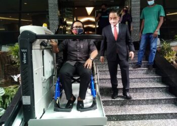 NG SUEE Lim (dua dari kiri) melihat mesin yang membantu orang kurang upaya (OKU) menaiki tangga di Bangunan Annex, Shah Alam, Selangor hari ini. - UTUSAN/MOHAMAD NAUFAL MOHAMAD IDRIS