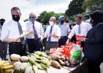 HISHAMMUDDIN Tun Hussein (kiri) bersama Ronald Kiandee (tiga dari kiri) melihat antara sumbangan makanan yang diserahkan pada Program Bakul Mindef Prihatin di Kuala Lumpur, hari ini. - UTUSAN/MOHD FARIZWAN HASBULLAH 