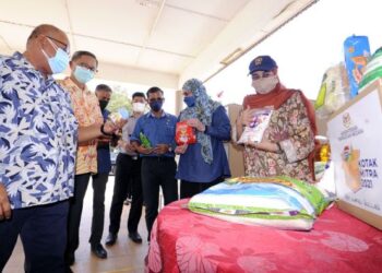 HALIMAH Mohamed Sadique (kanan) menunjukkan barangan makanan yang diagihkan kepada penduduk masyarakat India dalam kalangan golongan isi rumah B40 menerusi program agihan kotak makanan MITRA 2021 di Dewan Komuniti, Ladang Tanah Merah, Chuah, Port Dickson, hari ini. - FOTO/MOHD. SHAHJEHAN MAAMIN