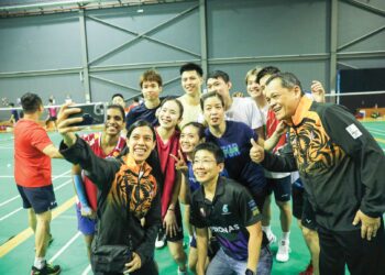 HAMIDIN Mohd. Amin (kanan) dan Nicol David (kiri) berswafoto dengan pemain badminton dalam lawatan ke Akademi Badminton Malaysia di Bukit Kiara baru-baru ini.