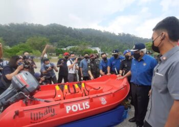 HAMZAH Zainudin (dua dari kanan) melihat bot jenis Whaly yang diserahkan kepada PDRM dalam lawatan kerja Pengurusan Banjir Pantai Timur di Kem PGA Galing, Pahang, semalam. – UTUSAN/DIANA SURYA ABD WAHAB