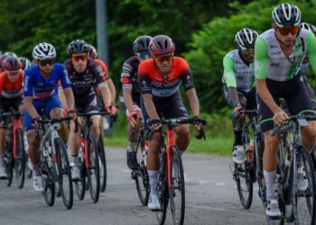 AKSI Muhd. Harrif Saleh (tengah) ketika berada dalam kelompok peloton pada peringkat keempat sejauh 137.9 kilometer dari Sabak Bernam ke Meru Raya, Ipoh hari ini. - UTUSAN/FARIZ RUSADIO