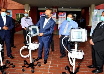 HASNI Mohammad (tengah) melihat mesin ventilasi sambil diperhatikan oleh R. Vidyananthan (kiri) dan Dr. Aman Rabu (kanan) pada majlis penyerahan tiga mesin itu kepada JKNJ di HSA, Johor Bahru, hari ini. - FOTO/RAJA JAAFAR ALI