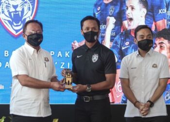 HASNI Mohammad (kiri) menyampaikan Anugerah Pelancongan Johor 20/21 Kelab Bola Sepak Johor Darul Ta'zim kepada pemjaga gol, Farizal Marlias pada Majlis Pra Pelancaran Johor Tourism Interchange (JTI) dan 'Virtual Majestic Johor Tourism Week 2021’ di Johor Bahru.