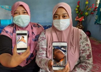 SITI Sarah Mat Isa (kanan) menunjukkan gambar Haziq Zikri manakala Haslina Mahmud pula menunjukkan gambar Firash Mikael Azrie Shah di Kampung Badlishah, Kulim, semalam. – UTUSAN/AZAHAR HASHIM