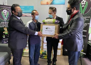 TUNKU Nur Muhammad Tunku Adnan (dua dari kanan) menyerahkan kotak makanan ICFL Prihatin kepada penerima sambil disaksikan Kamil Mohktar (kanan).