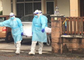 POLIS yang berpakaian peralatan perlindungan diri (PPE) mengangkat mayat dua lelaki yang ditemukan mati di sebuah rumah di Taman Datuk Setia, Jalan Kaki Bukit, Kangar, Perlis hari ini.- UTUSAN