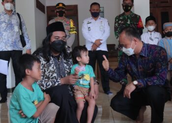 ZUDAN Arif Fakrulloh memberikan kad pengenalan kepada kanak-kanak yang sebelum ini memiliki nama dengan 19 perkatan. - AGENSI