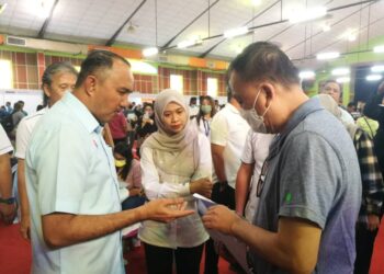 MOHD. JAFNI MD SHUKOR (kiri) dan Suhailizan mendengar aduan yang dibangkitkan oleh pembeli pada Program J-Home One Stop Center di Dewan Bandar Putra, Kulai.