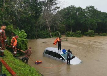 TIGA beradik terpaksa memanjat bumbung kenderaan selepas terperangkap dalam banjir di Jalan Impian, Taman Impian, Labis, Segamat.