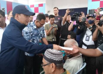 ONN Hafiz Ghazi (bertopi biru) menyampaikan sumbangan sambil beramah mesra dengan mangsa banjir di PPS Dewan Serbaguna Kampung Paya Merah, Labis, Segamat.