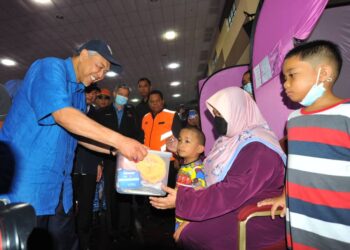 AHMAD ZAHID HAMIDI menyampaikan bantuan kepada mangsa banjir di PPS Politeknik Mersing.