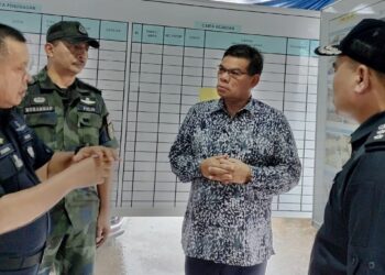 SAIFUDDIN NASUTION ISMAIL.(dua dari kanan) mendengar penerangan tentang banjir di Kahang, Kluang oleh Ketua Polis Johor, Datuk Kamarulzaman Mamat (kiri).